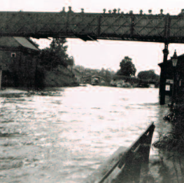 The flood of 1935, showing the station platform awash and spectators taking in the view